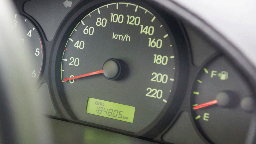 Conducteur vérifiant le compteur kilométrique de son véhicule avant déclaration assurance